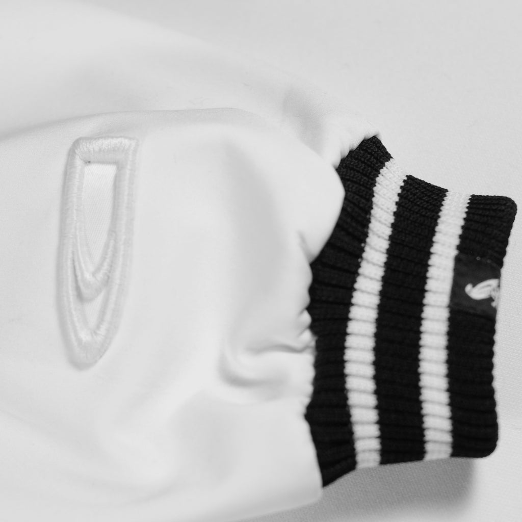 White jacket by Crowdead. Sleeve CD Bullet embroidered logo closeup.